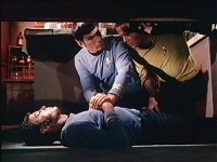 Spock und Kirk beobachten, wie bei McCoy die Wirkung eintritt.